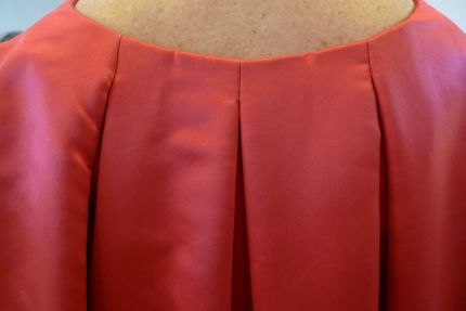 The beautiful pleats at the elegantly-placed top\ back edge.