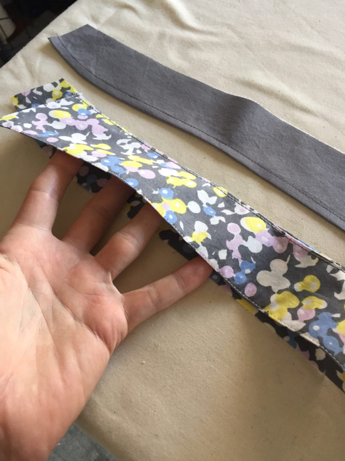 Men's shirt collar piece cut from printed fabric is shown with the gray fabric outer collar stand
