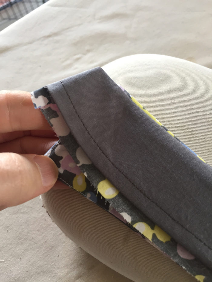 The sewn men's shirt collar piece lays over a tailor's ham