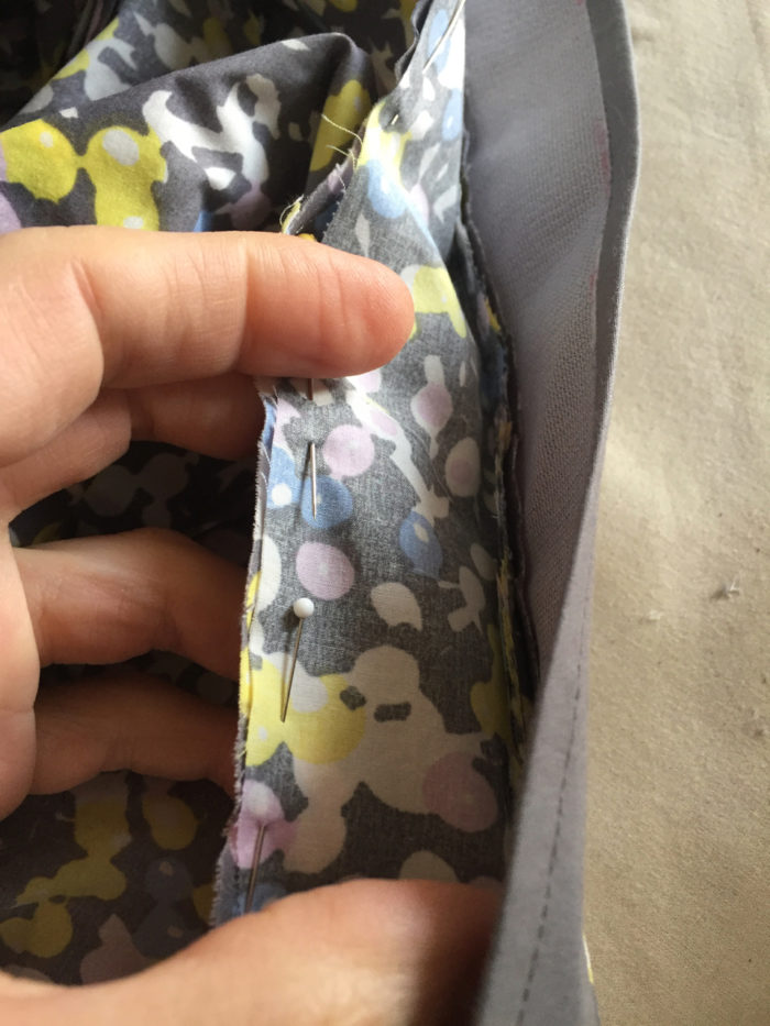 The shirt collar stand is pinned to the neckline edge