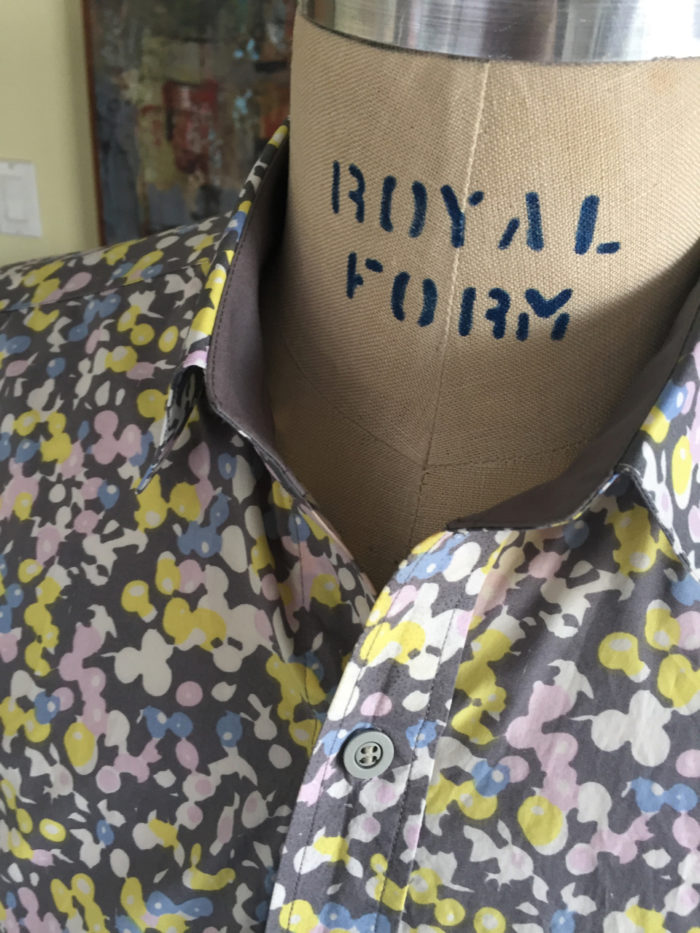 Close-up of completed printed men's shirt with gray collar stand on a dress form