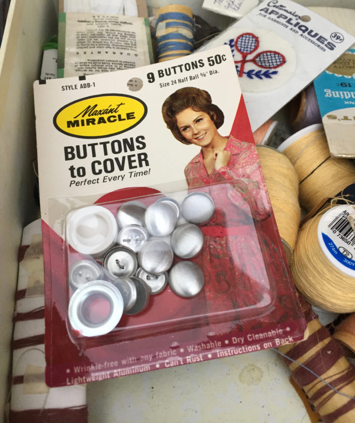 Button covers in original packaging picturing a woman home sewer