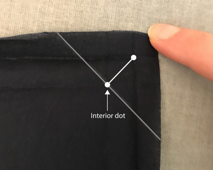 Close-up of place mat backing fabric corner showing locations of interior dot and line markings