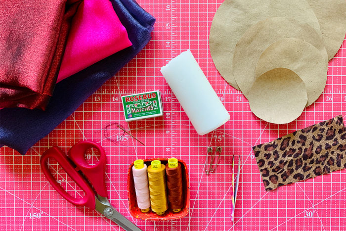 Supplies for making fabric flowers laid out on a cutting mat