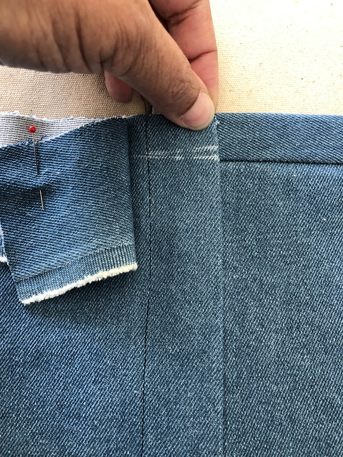 Tug and mark the wider seam allowance above the mock fly zipper
