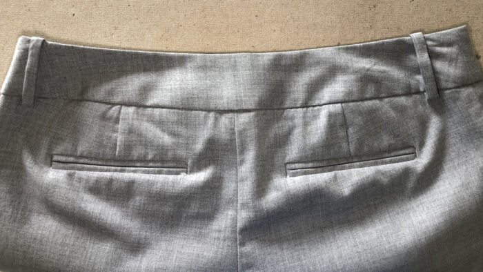 A pair of women's pants has a back waistband without a seam