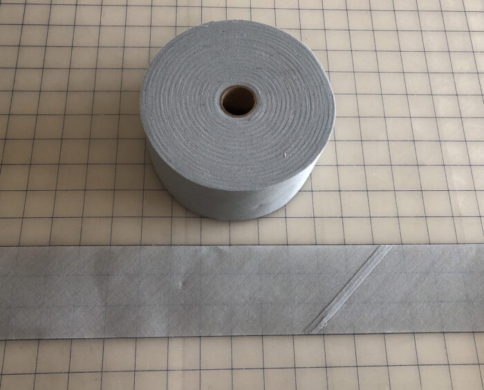 Wigan, a type of hem interfacing, on a roll and laid out on a gridded cutting mat