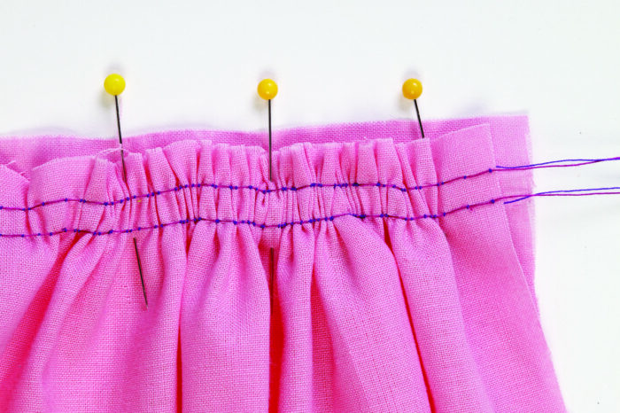 Double row of stitching gathers fabric, which is pinned to ungathered fabric