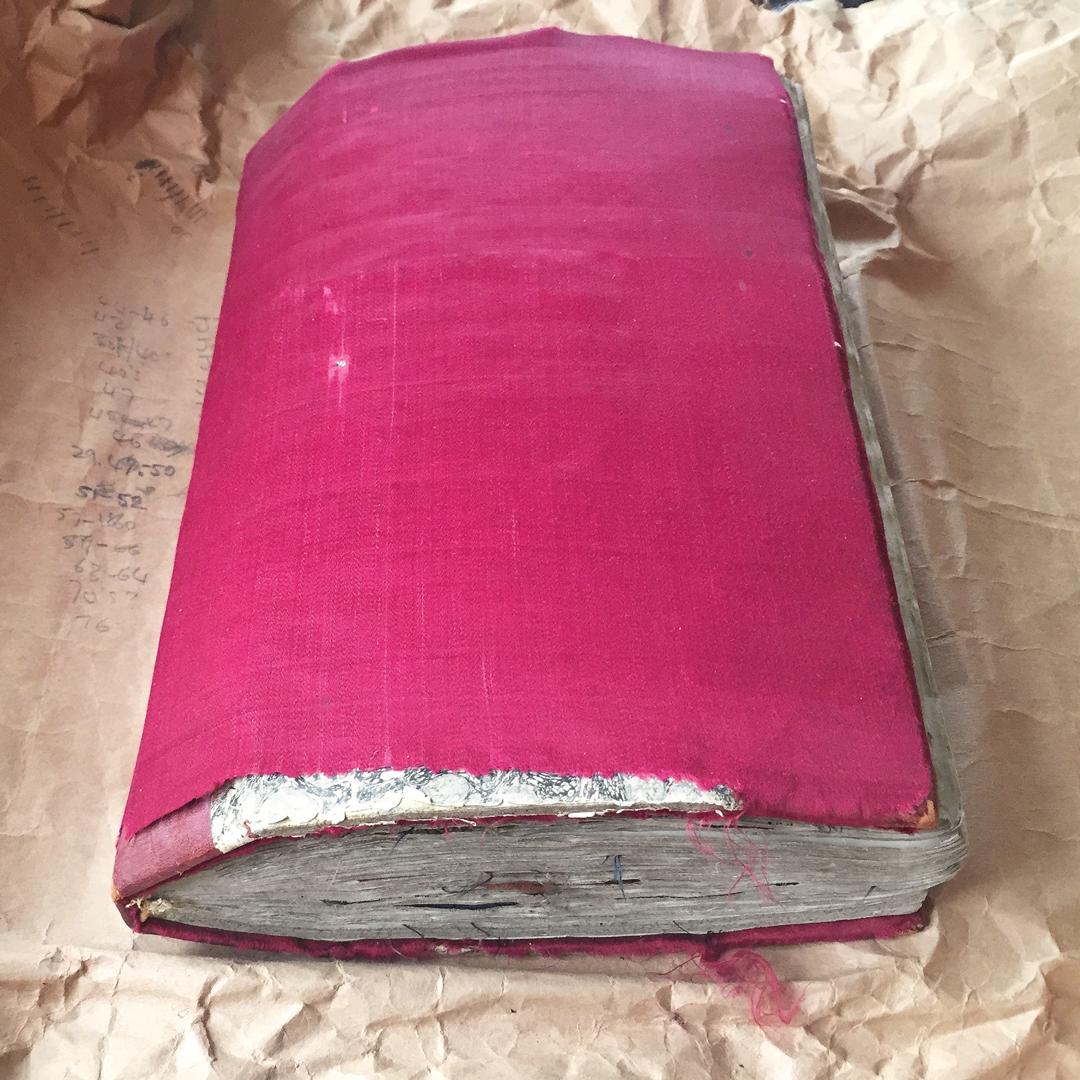 Worn pink silk covers a lovingly compiled collection of textile swatches. Each piece hints at the story of fashion, commerce, and women’s lives in the 1800s. 