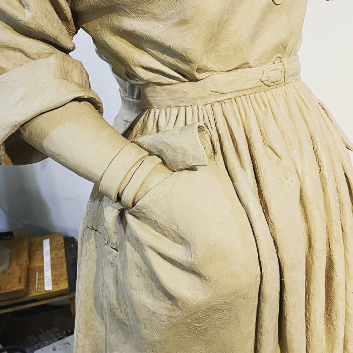 Close-up of Claire McCardell sculpture shows the figure's right hand in the dress's pocket