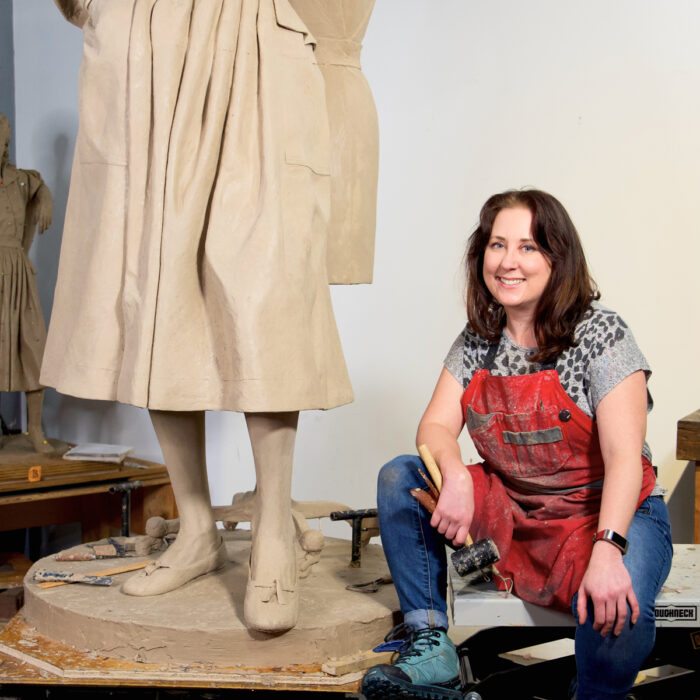 Sculptor Sarah Hempel Irani sits at the base of her Claire McCardell depiction which will be cast in bronze