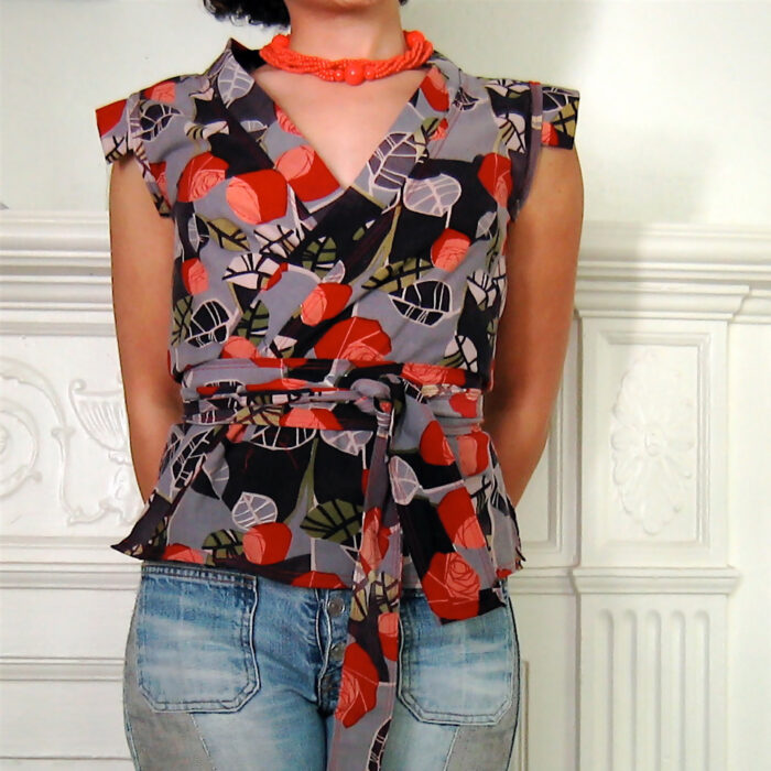 Woman wearing a bold print wrap top with a pair of jeans 