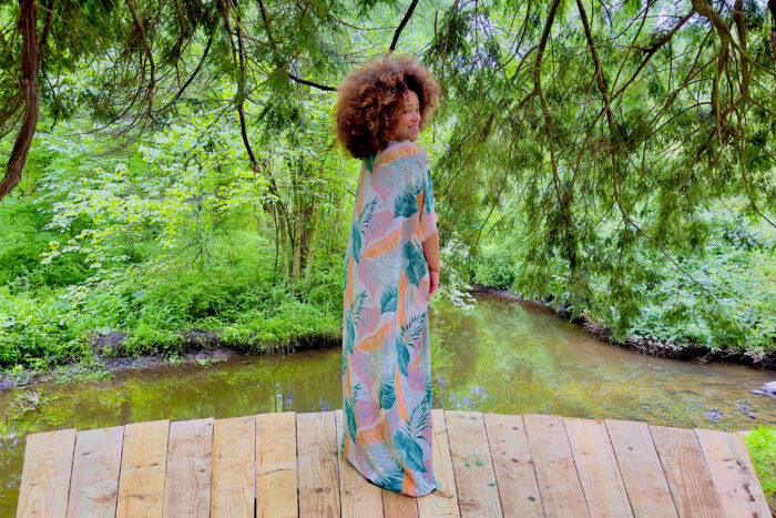 Marcy Harriell wearing a large-print caftan in a natural green scene