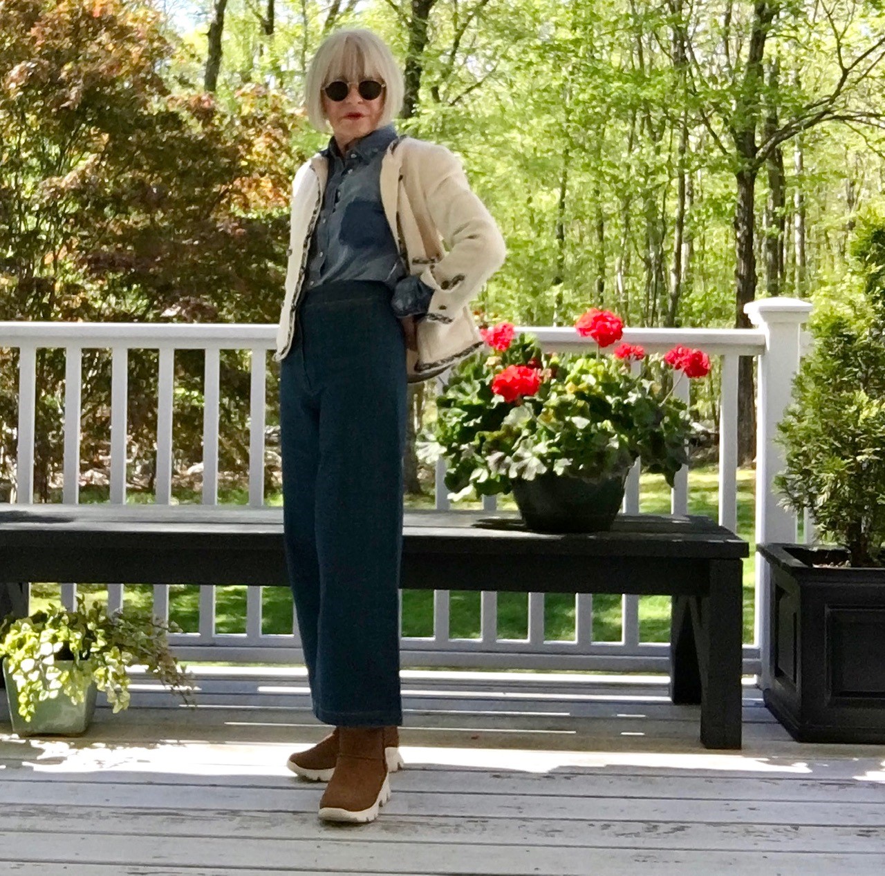 Blanca wears a cream Chanel-style jacket and dark trousers.