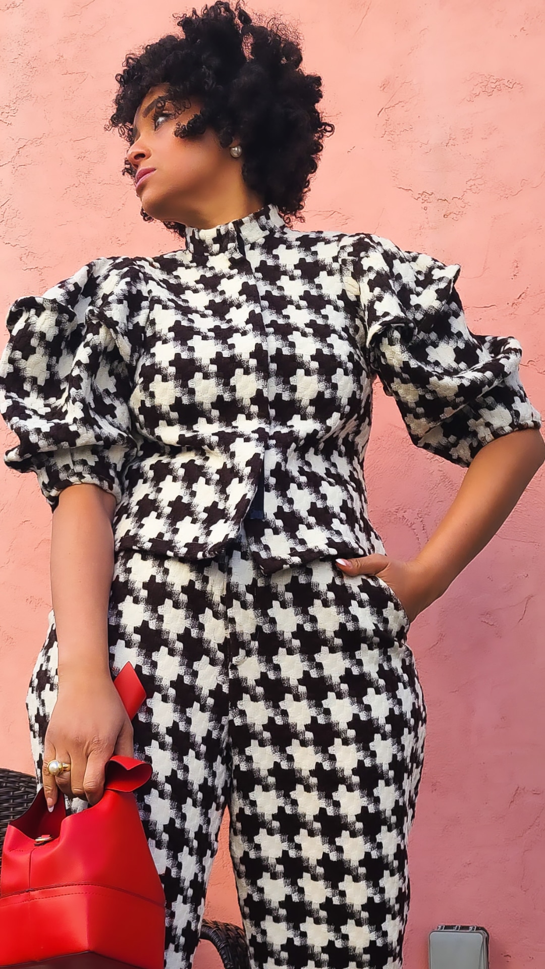 Marcia Spencer in black and white houndstooth outfit, with red bag