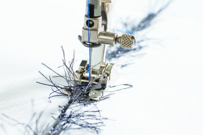 Eyelash yarn feeding into a couching presser foot.