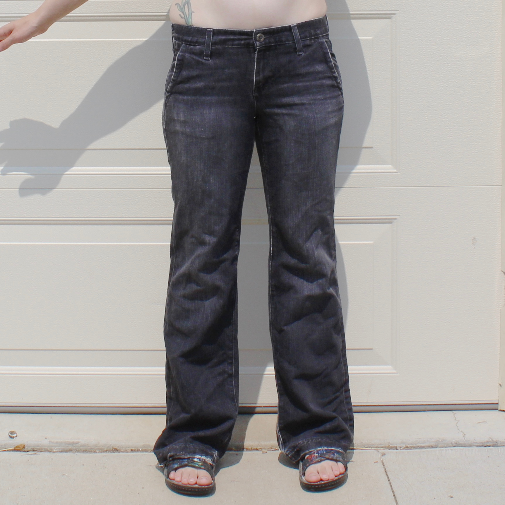 Figure shown from waist down in distressed jeans.