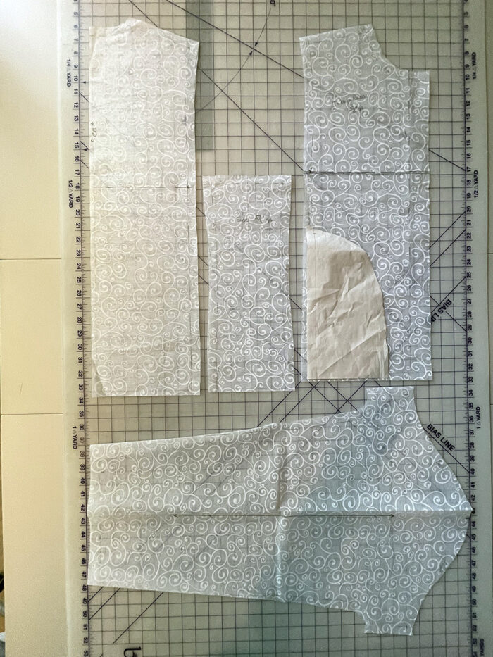 Copycat cardi pattern pieces laid out on gridded cutting mat