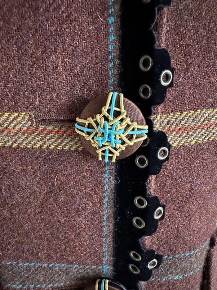 Close-up of passementerie-embellished designer jacket button