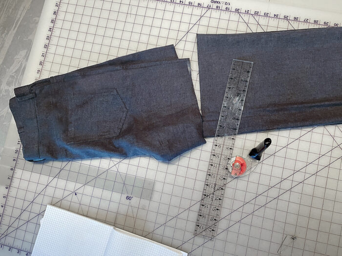 Cut pair of jeans lying on a gridded cutting mat