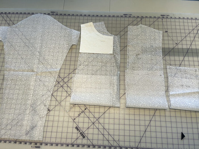 White pattern pieces lying on a gridded surface