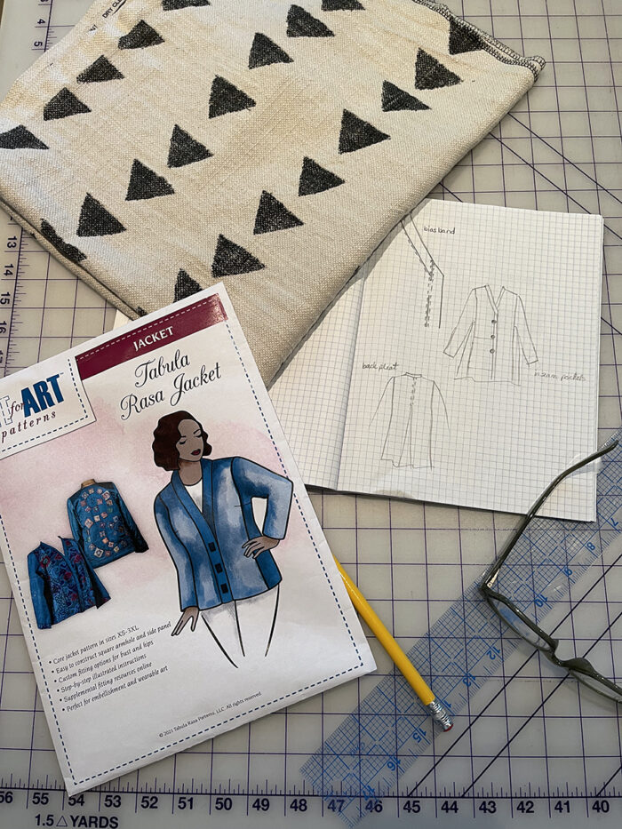 Fit for Art Patterns Tabula Rasa Jacket lying next to fabric and jacket sketch on gridded worksurface