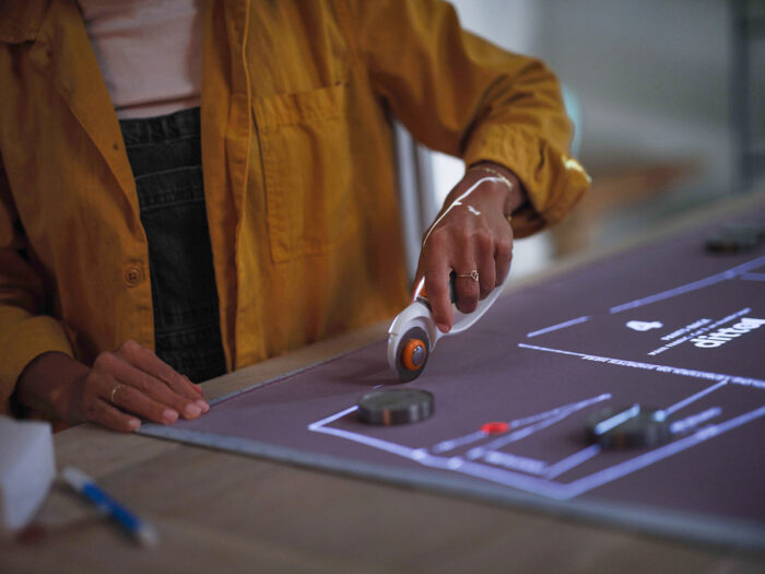 Fabric with a projected pattern is being cut with a rotary cutter 