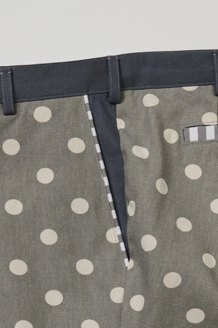 Close-up of striped piping on front pocket of polka dot shorts