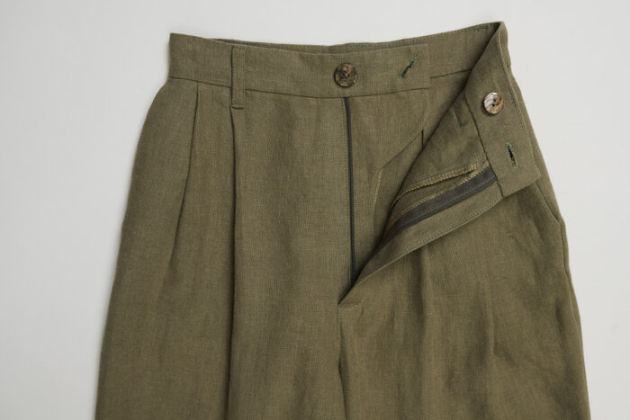 Close-up of unzipped green linen trousers