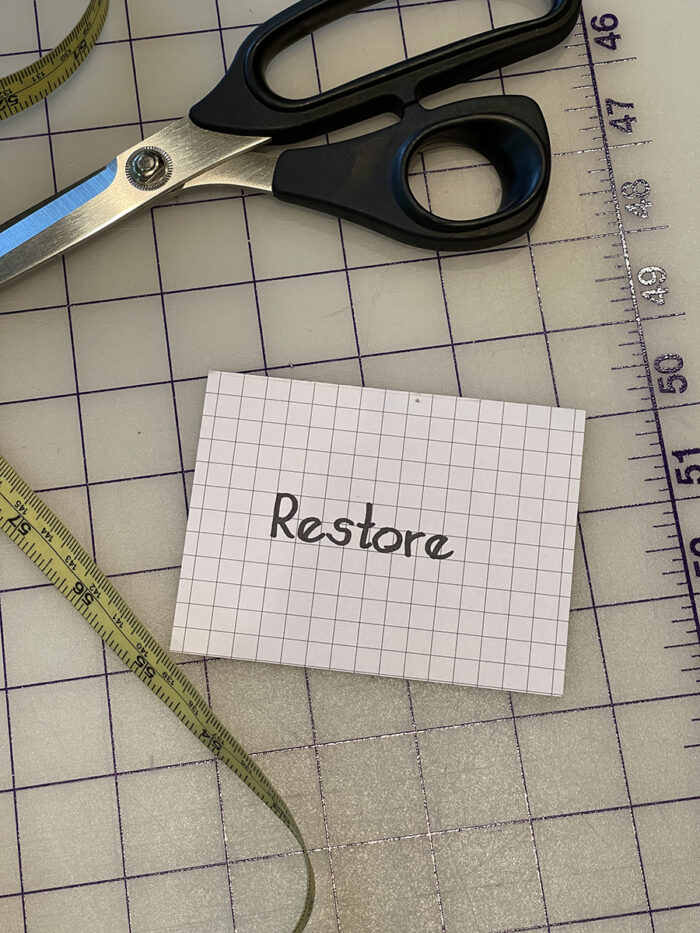 The Year of "Re": Restore card on gridded mat with scissors and tape measure nearby