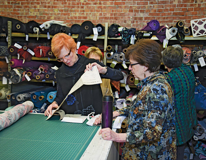 instructor showing woman how to sew