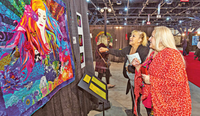 two women admiring quilt