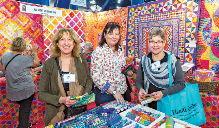 three women smiling at quilt expo