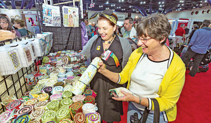 women picking out quilt materials at expo